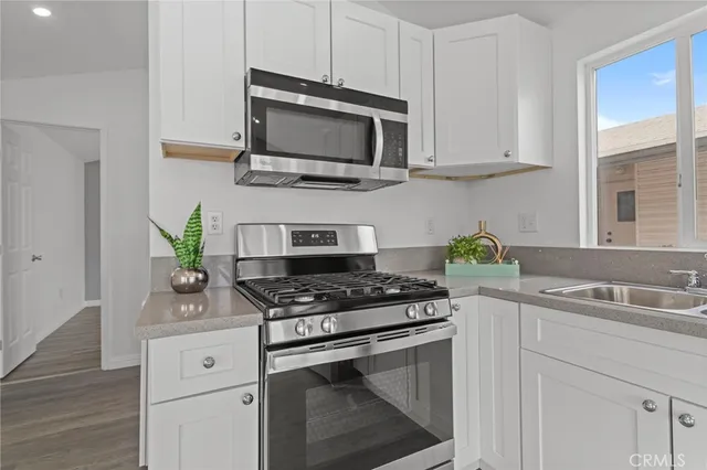 a kitchen with stainless steel appliances white cabinets and a stove top oven