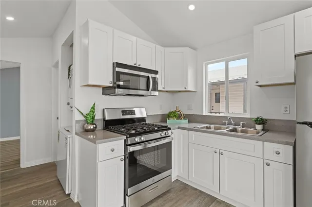 a kitchen with cabinets stainless steel appliances a sink and a stove