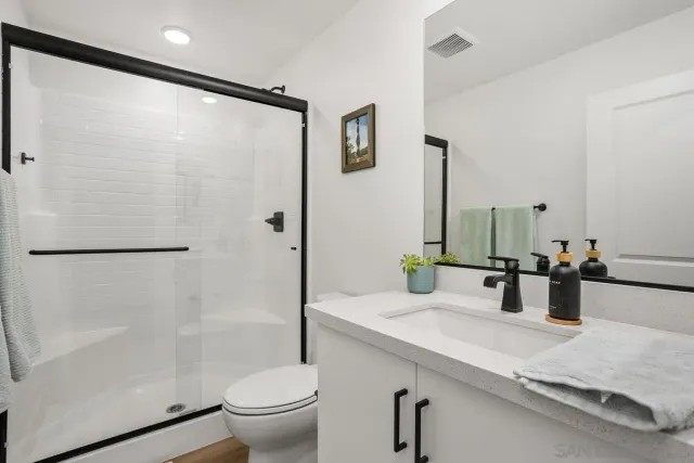 a bathroom with a double vanity sink toilet and shower