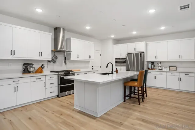 a kitchen with granite countertop white cabinets and white appliances