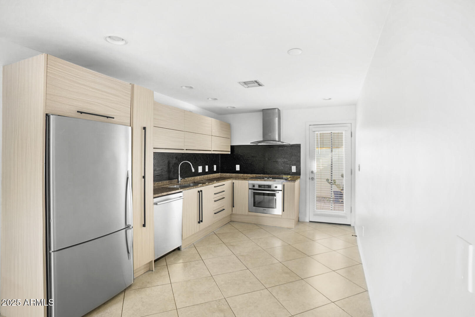 a kitchen with stainless steel appliances granite countertop a refrigerator sink and stove