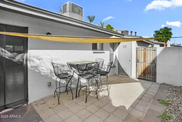 a view of a patio with table and chairs with wooden floor and fence