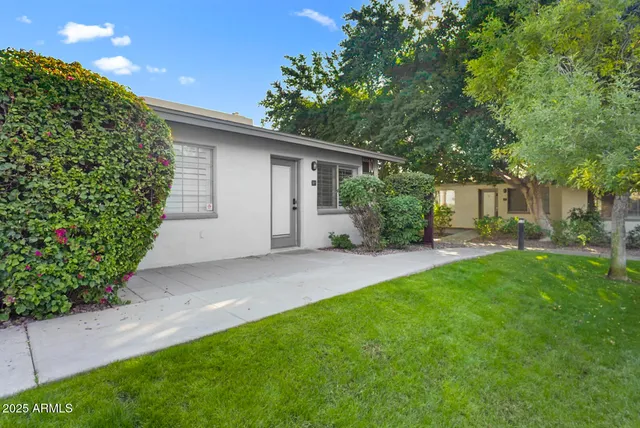 a view of a house with a yard and potted plants