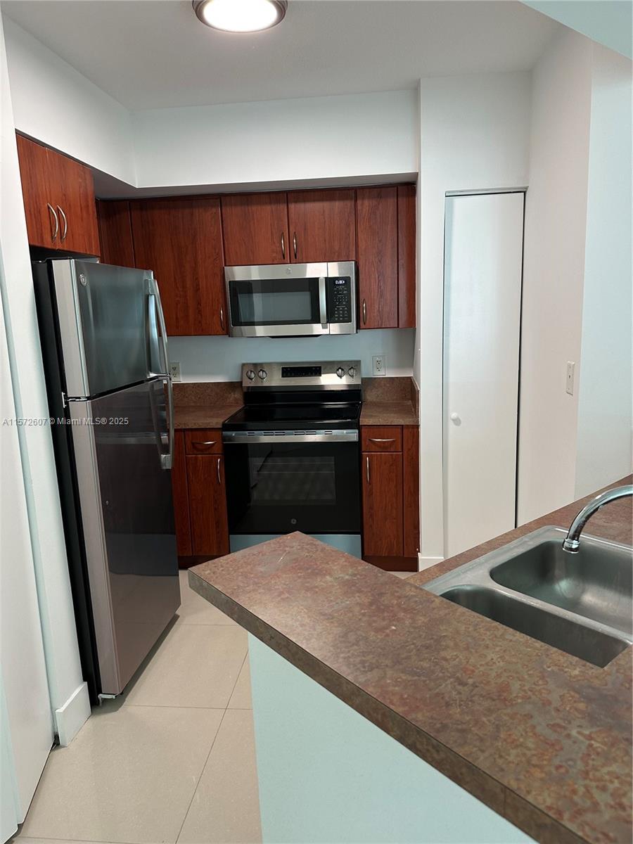 9201 Collins Avenue, Unit 524 Surfside, FL 33154 - Photo 7 of 20 a kitchen with stainless steel appliances a refrigerator and a sink