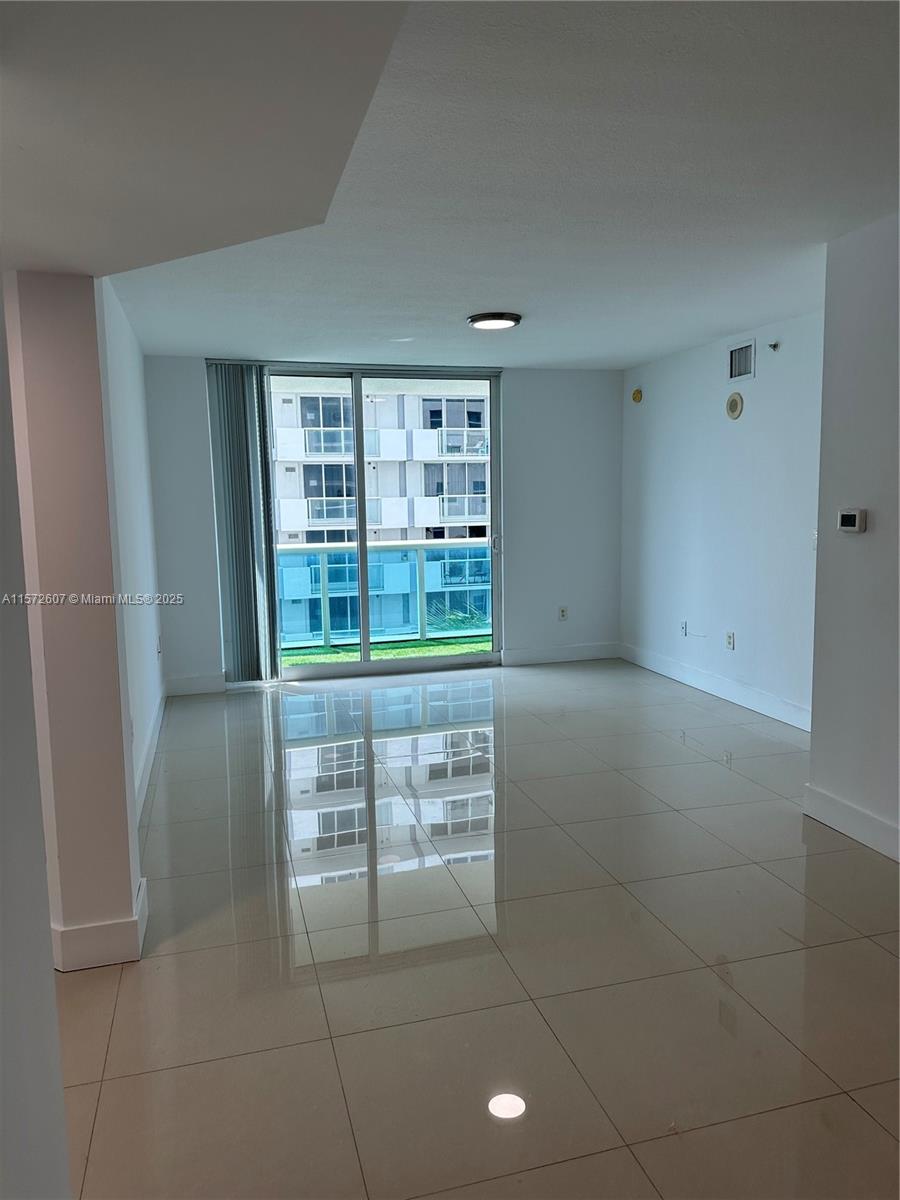 9201 Collins Avenue, Unit 524 Surfside, FL 33154 - Photo 8 of 20 a view of kitchen with granite countertop tops and white cabinets