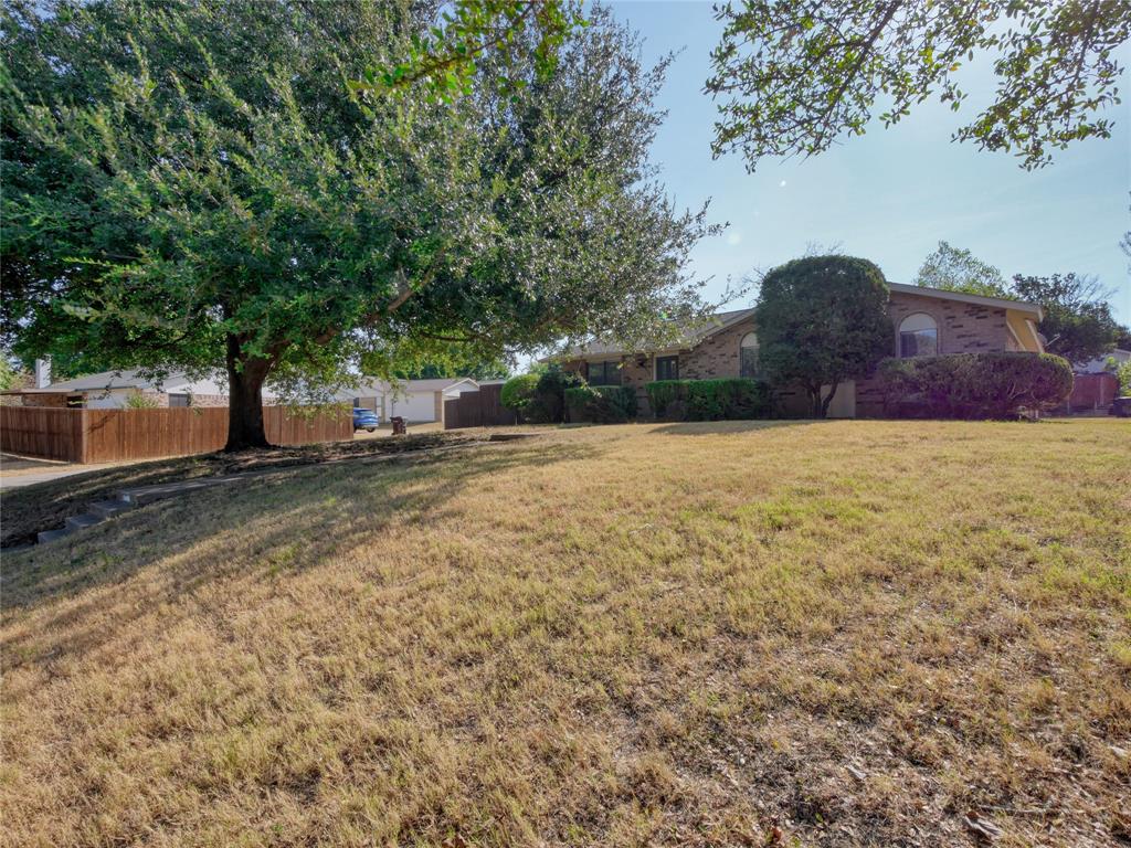 1472 Rockshire Drive Plano, TX 75074 - Photo 4 of 27 Brick exterior home with arched windows, mature landscaping, and an expansive front yard