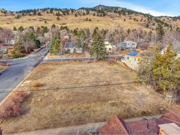 a big yard with trees and cars parked in front of it