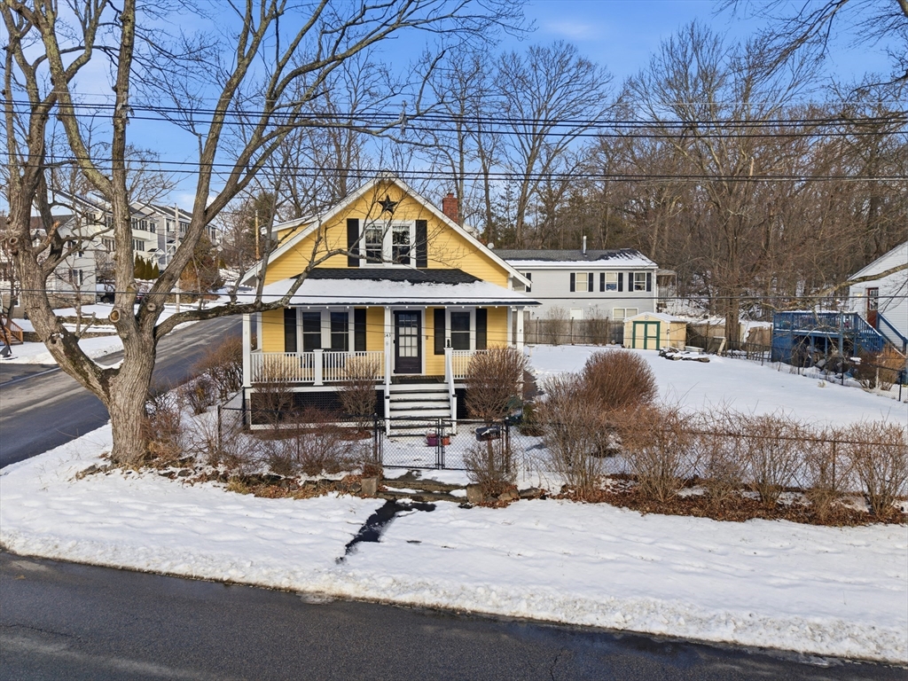 a front view of a house with yard and trees around