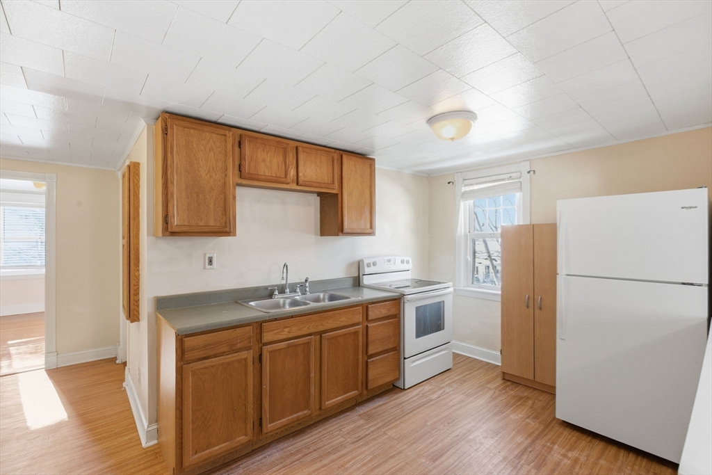 143 Commonwealth Avenue Worcester, MA 01604 - Photo 19 of 35 a kitchen with a refrigerator a sink and wooden floor