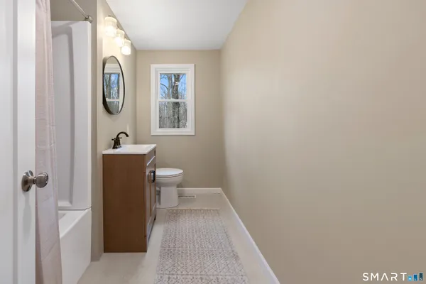 a bathroom with a toilet and a mirror