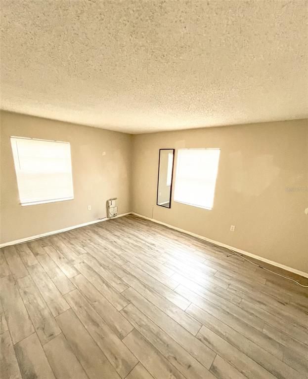 4335 Aegean Drive, Unit 108A Tampa, FL 33611 - Photo 3 of 16 an empty room with wooden floor and windows