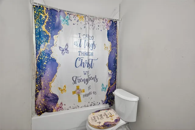 a bathroom with a toilet and a shower curtain