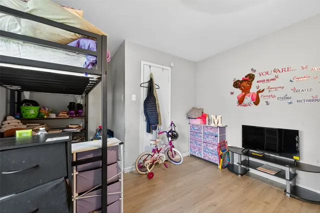 a bedroom with a bed a flat screen tv and a chandelier