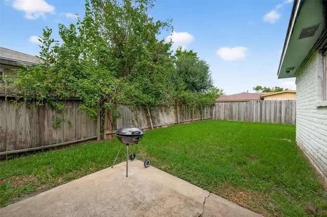 a view of a yard in front of a house with large trees