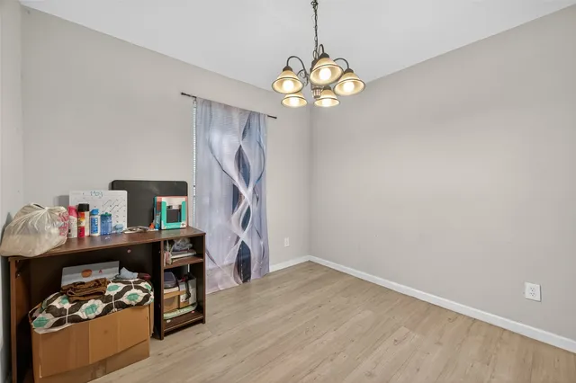 a dining room with furniture a chandelier and wooden floor