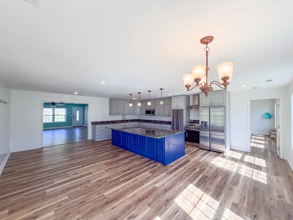 a view of a living room and kitchen with wooden floor