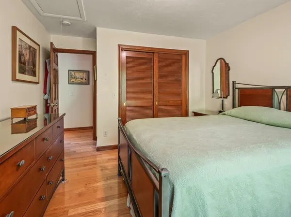 a bedroom with a bed and a dresser with mirror