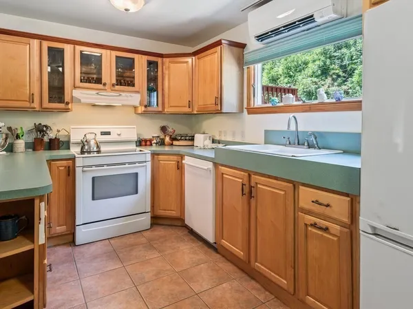 a kitchen with stainless steel appliances granite countertop a stove a sink dishwasher and a refrigerator