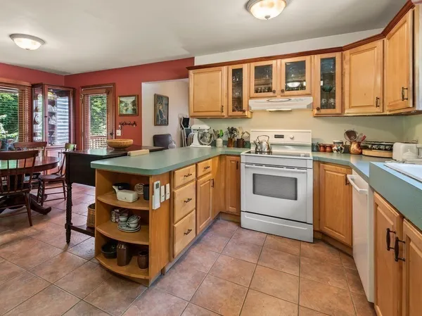 a kitchen with stainless steel appliances granite countertop a stove a sink dishwasher and cabinets with wooden cabinets