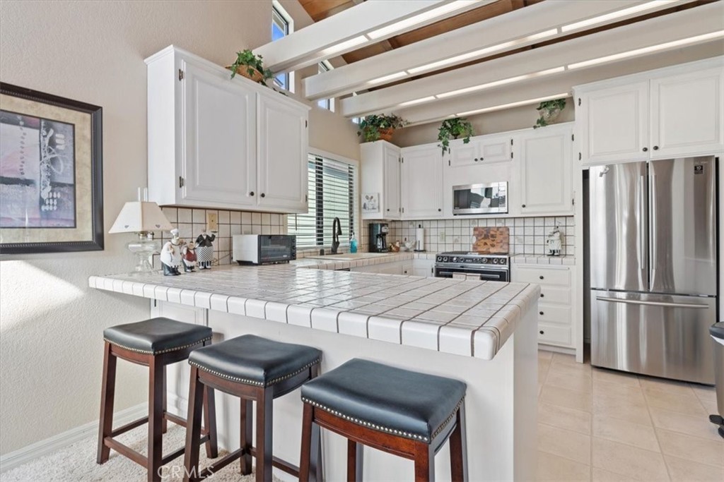 498 Croyden Lane Cambria, CA 93428 - Photo 33 of 68 a kitchen with stainless steel appliances granite countertop a sink refrigerator and cabinets
