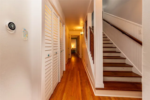 a view of a hallway with wooden floor and staircase