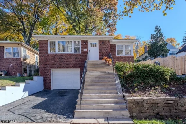 a front view of a house with a garden and plants