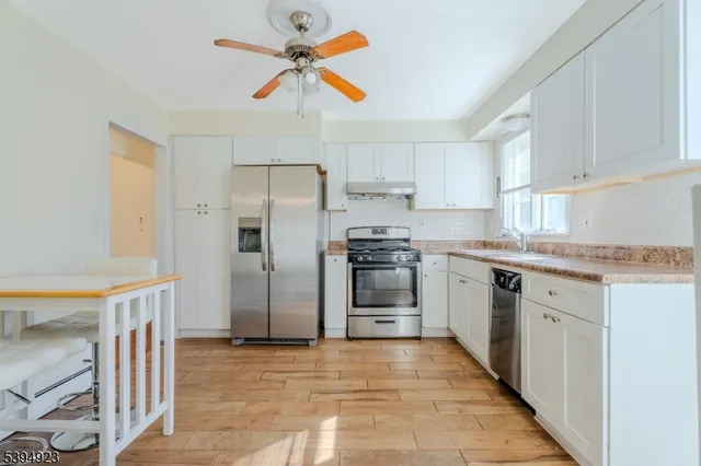 a kitchen with granite countertop a refrigerator and a sink