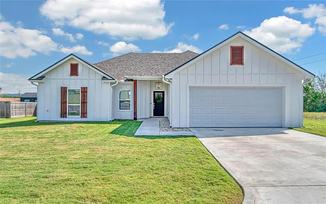 a front view of house with yard and trees