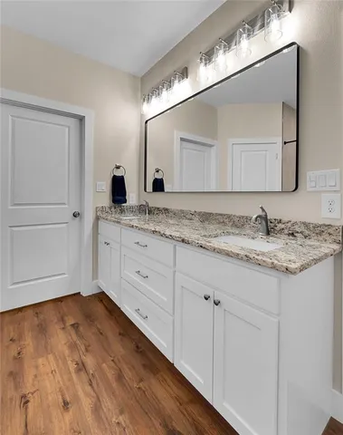 a bathroom with a granite countertop sink and mirror