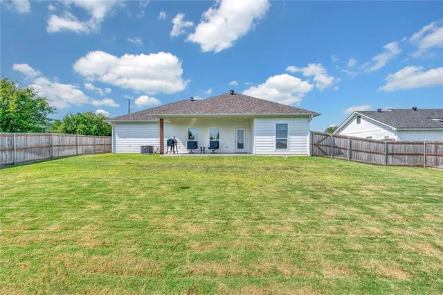 a view of a house with a big yard and a large tree
