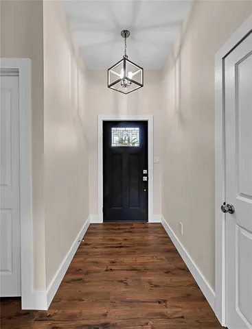 a view of a hallway with wooden floor and a chandelier