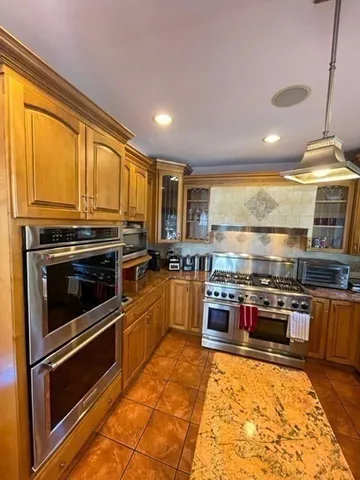 a kitchen with stainless steel appliances granite countertop a stove a sink and a microwave