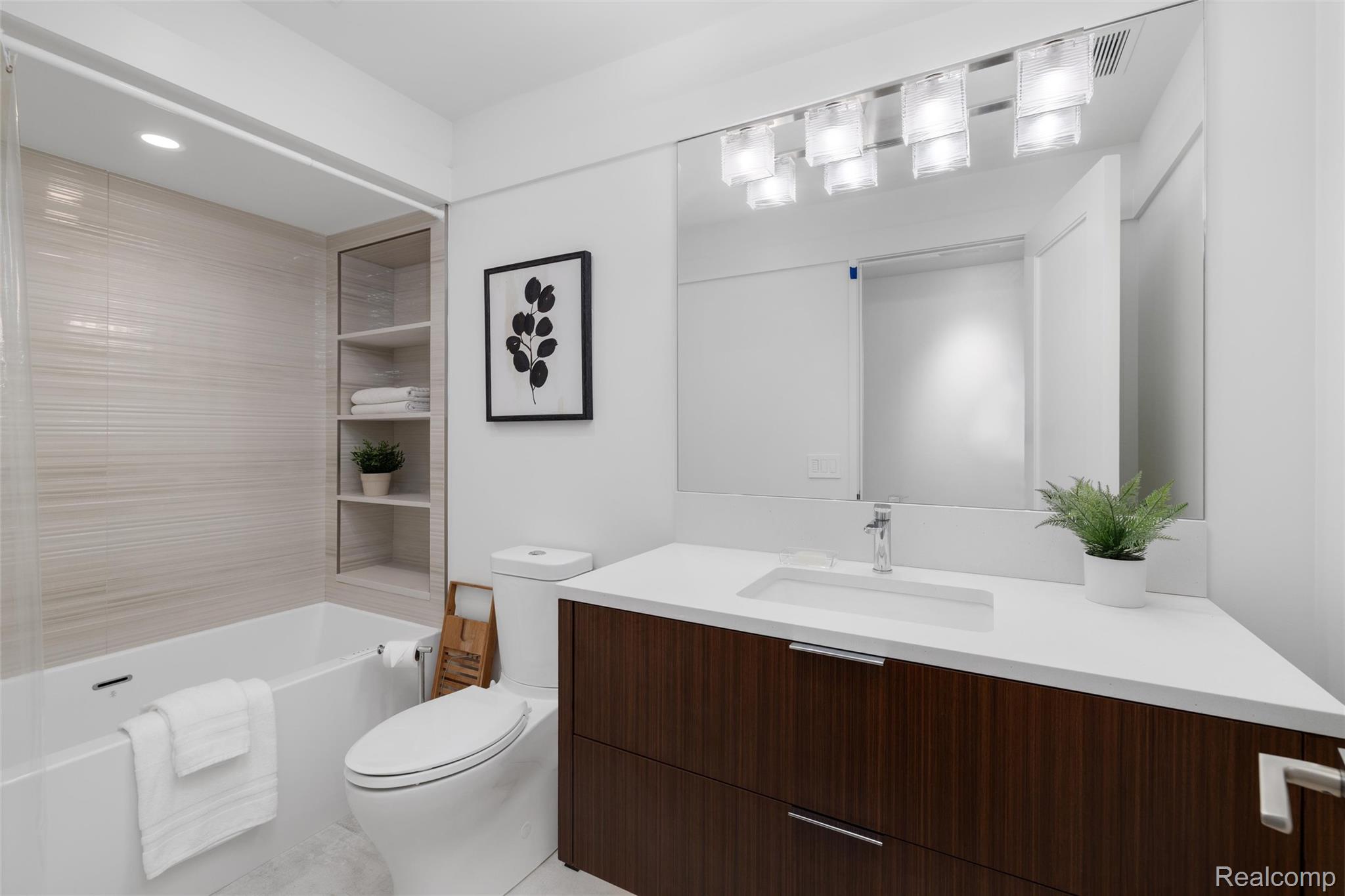 2700 Squirrel Road Bloomfield Hills, MI 48304 - Photo 49 of 83 Contemporary bathroom featuring a dark wood-finish vanity with an integrated white sink and a wide mirror
