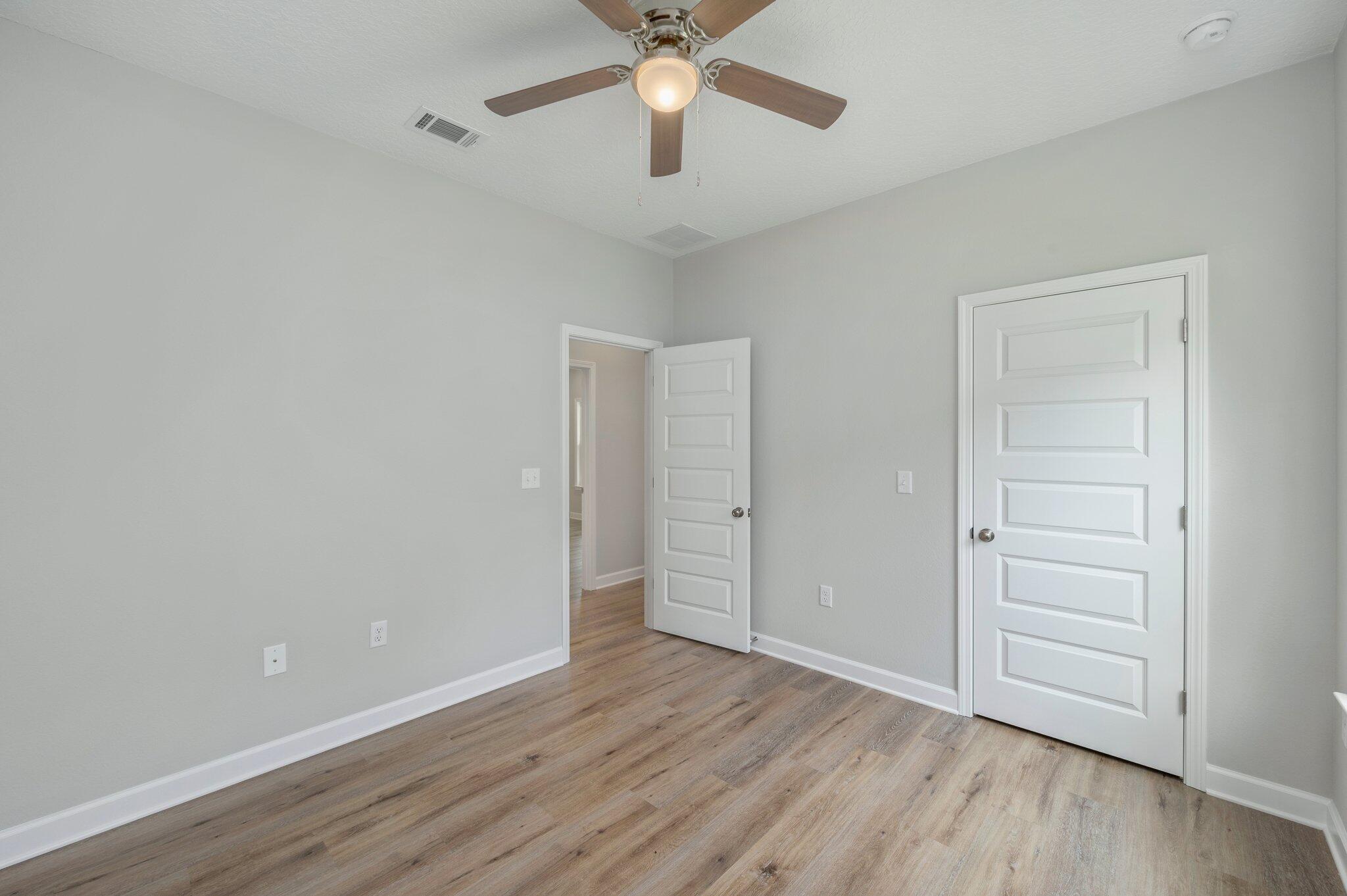 95 Live Oak Street Freeport, FL 32439 - Photo 15 of 26 an empty room with wooden floor closet and ceiling fan