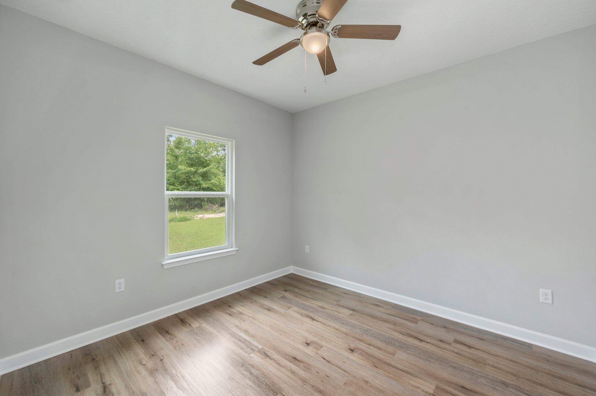 95 Live Oak Street Freeport, FL 32439 - Photo 16 of 26 an empty room with wooden floor and windows