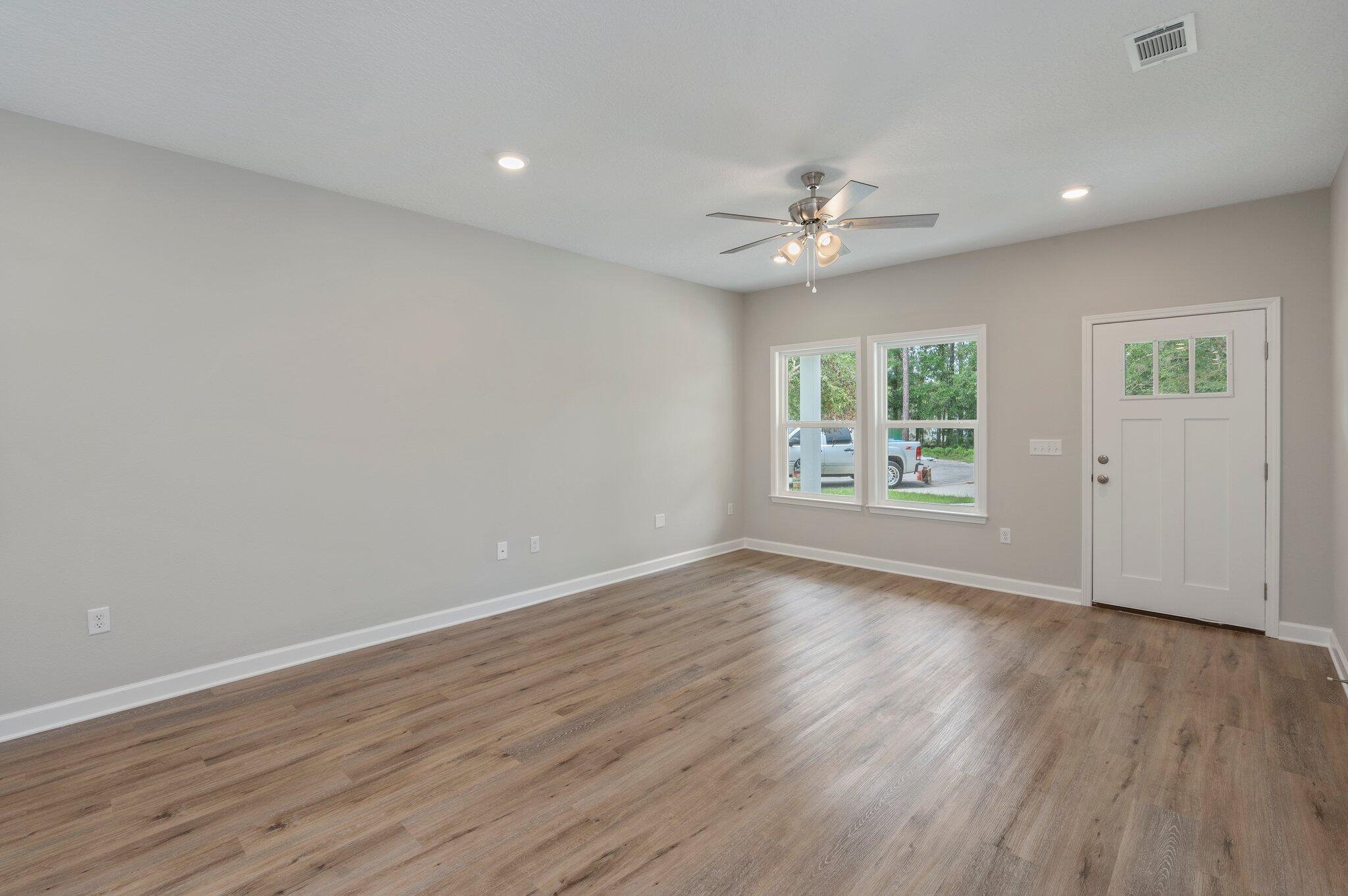 95 Live Oak Street Freeport, FL 32439 - Photo 8 of 26 an empty room with wooden floor ceiling fan with window