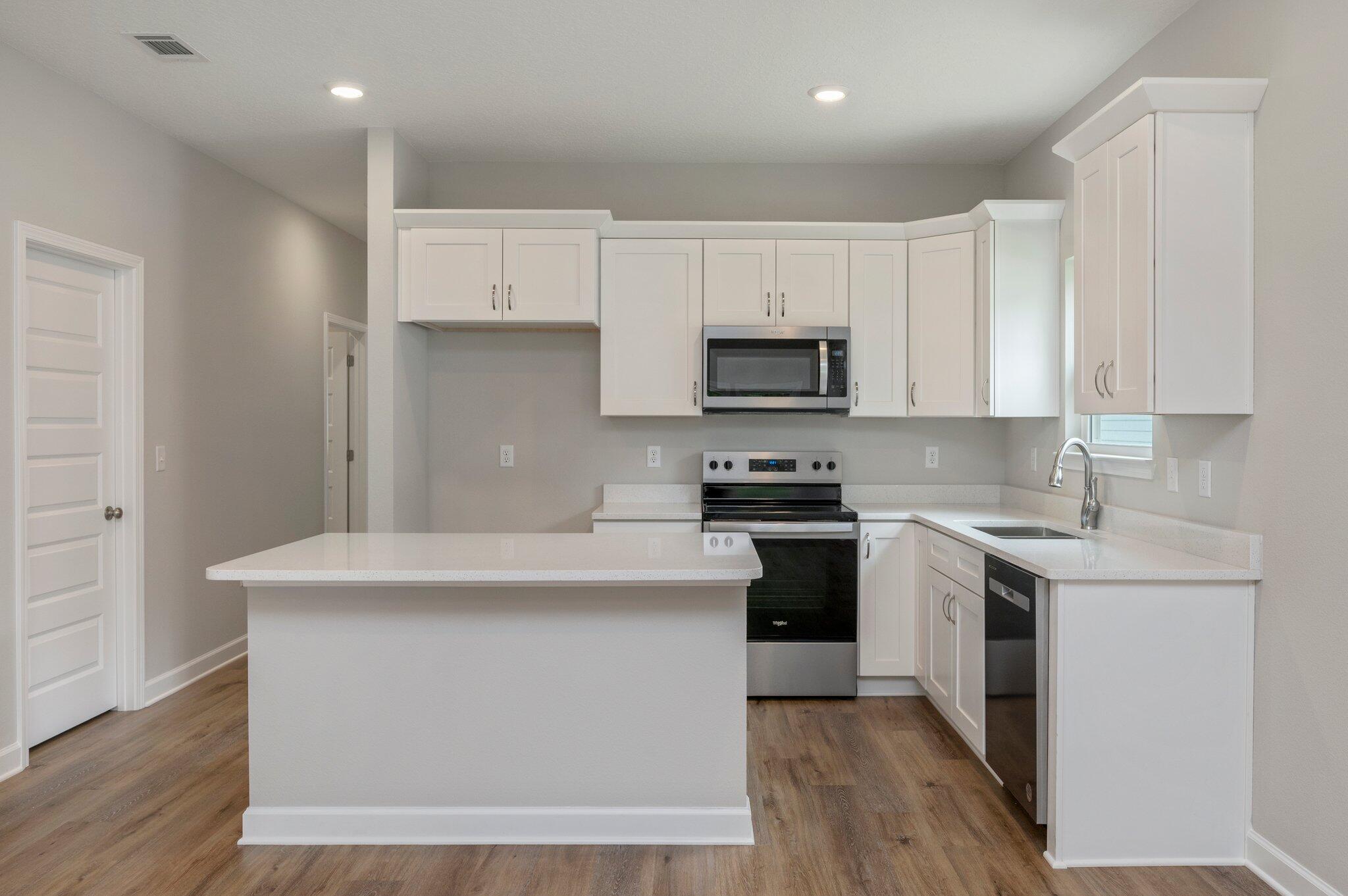 95 Live Oak Street Freeport, FL 32439 - Photo 9 of 26 a kitchen with stainless steel appliances a sink a stove a microwave a sink a refrigerator and cabinets
