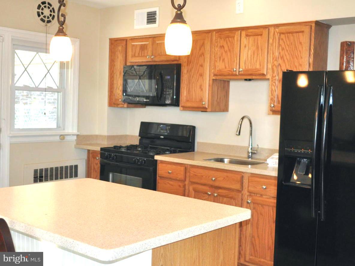 3900 Rexmere Road Baltimore, MD 21218 - Photo 12 of 23 a kitchen with stainless steel appliances a sink stove and refrigerator