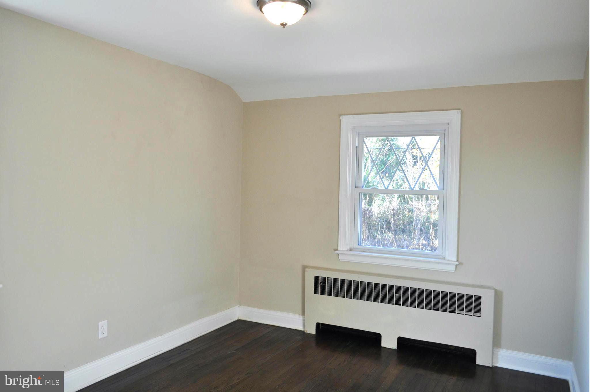 3900 Rexmere Road Baltimore, MD 21218 - Photo 17 of 23 a view of an empty room with wooden floor and a window