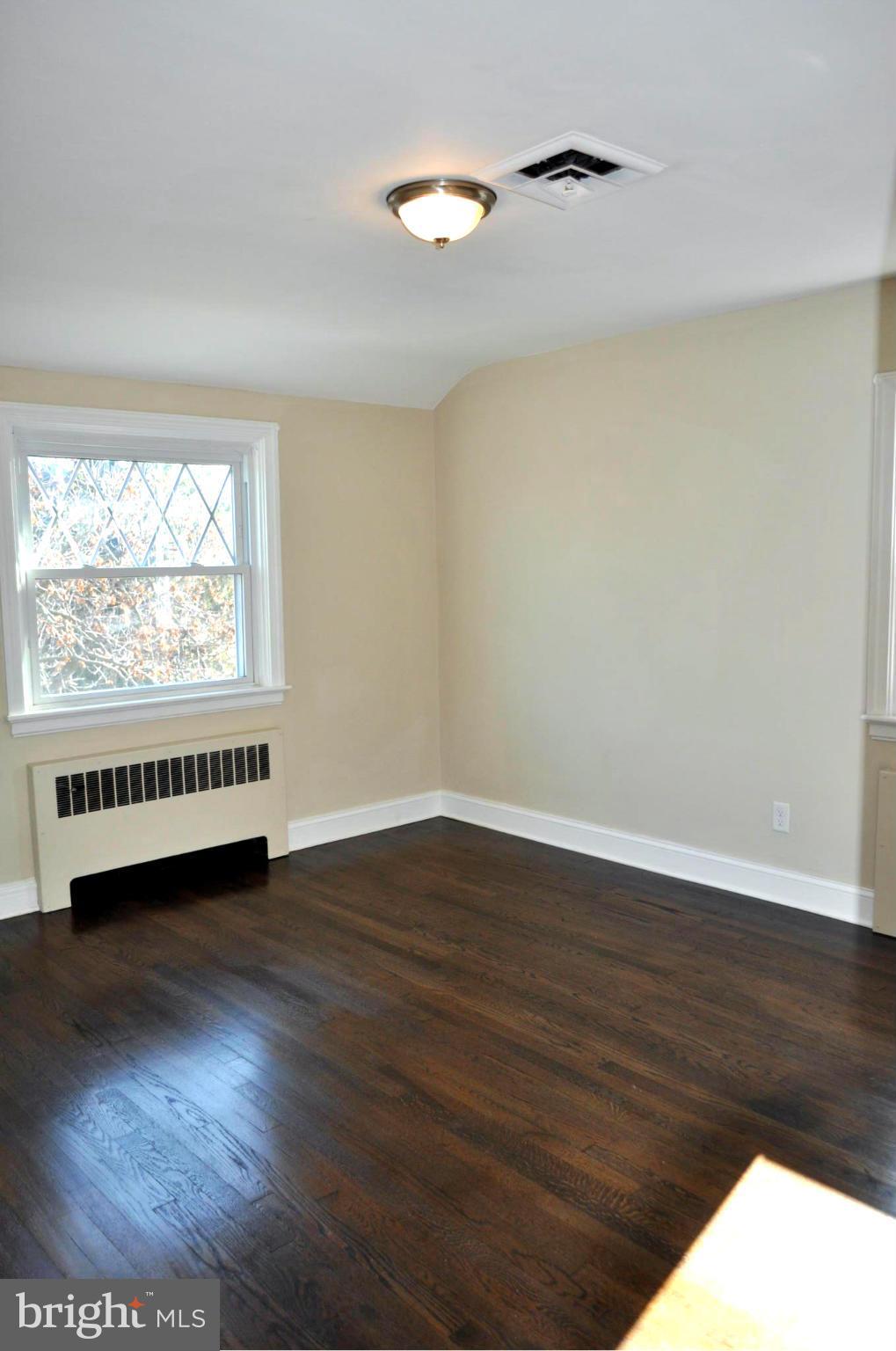 3900 Rexmere Road Baltimore, MD 21218 - Photo 7 of 23 a view of an empty room with wooden floor and a window