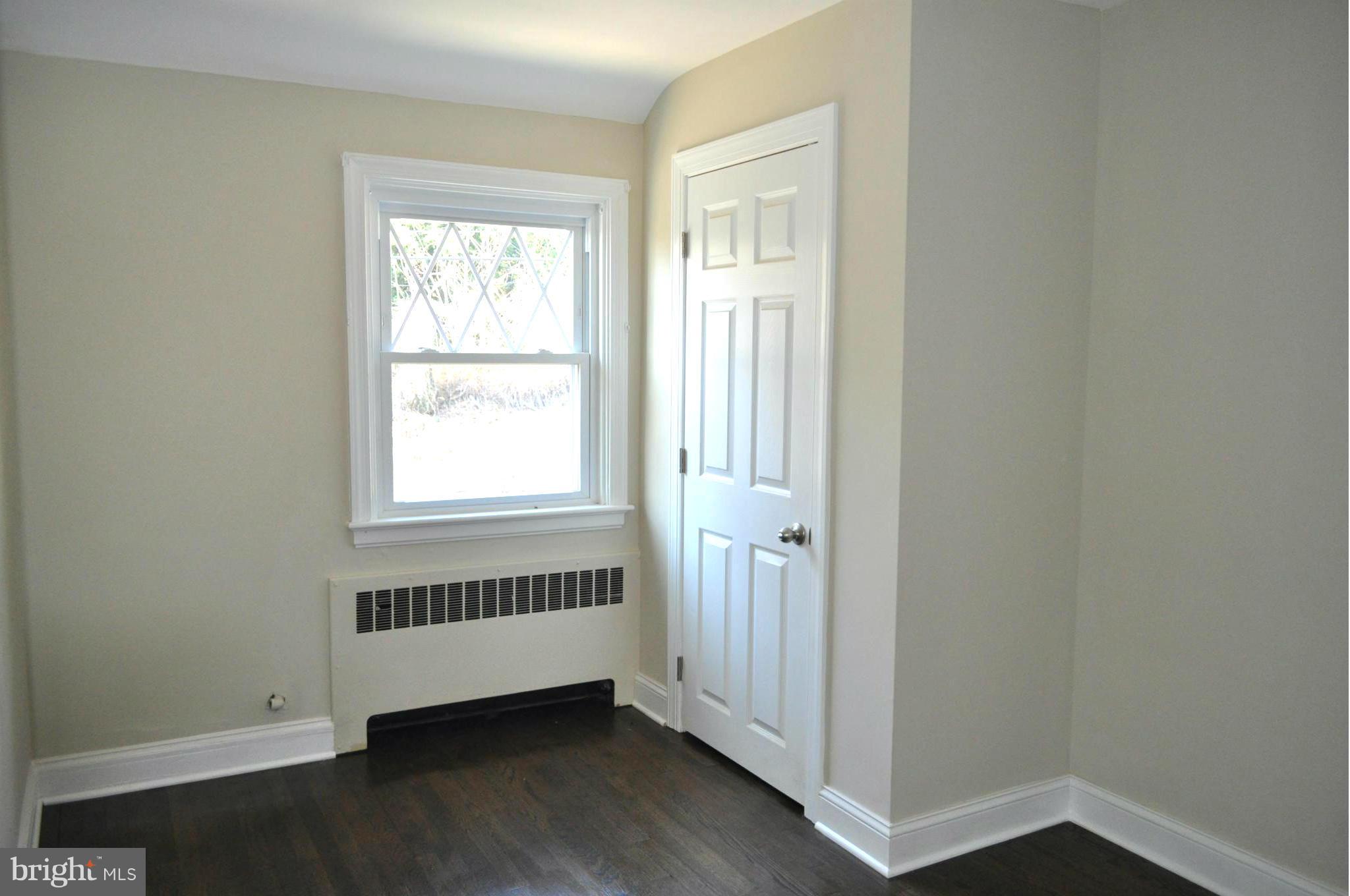 3900 Rexmere Road Baltimore, MD 21218 - Photo 8 of 23 an empty room with wooden floor and windows