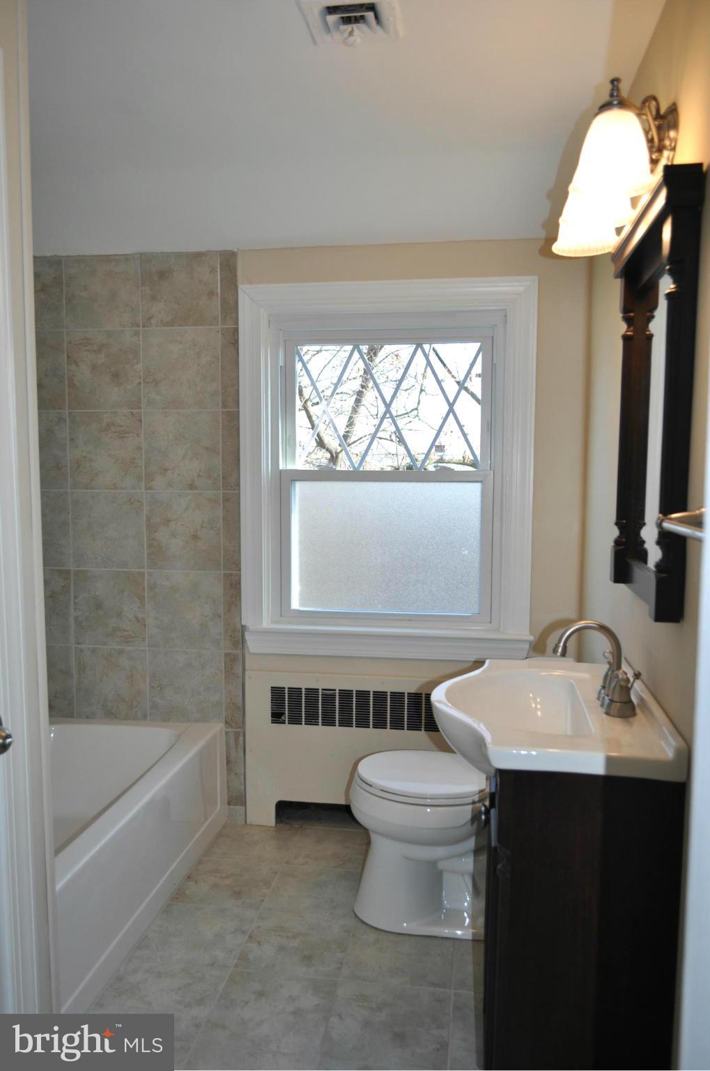 3900 Rexmere Road Baltimore, MD 21218 - Photo 9 of 23 a bathroom with a sink a toilet and bathtub