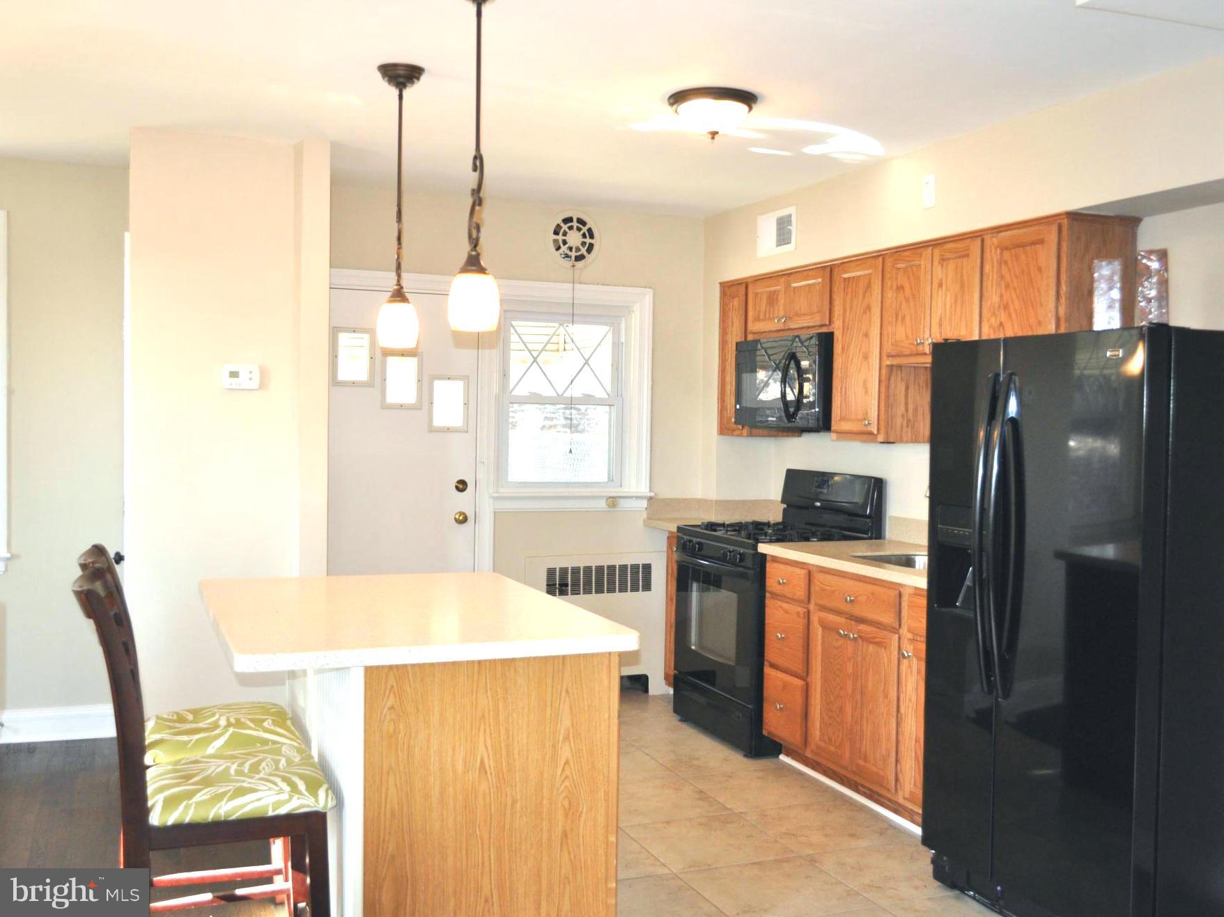 3900 Rexmere Road Baltimore, MD 21218 - Photo 10 of 23 a kitchen with stainless steel appliances a refrigerator a stove a sink dishwasher with a dining table and chairs