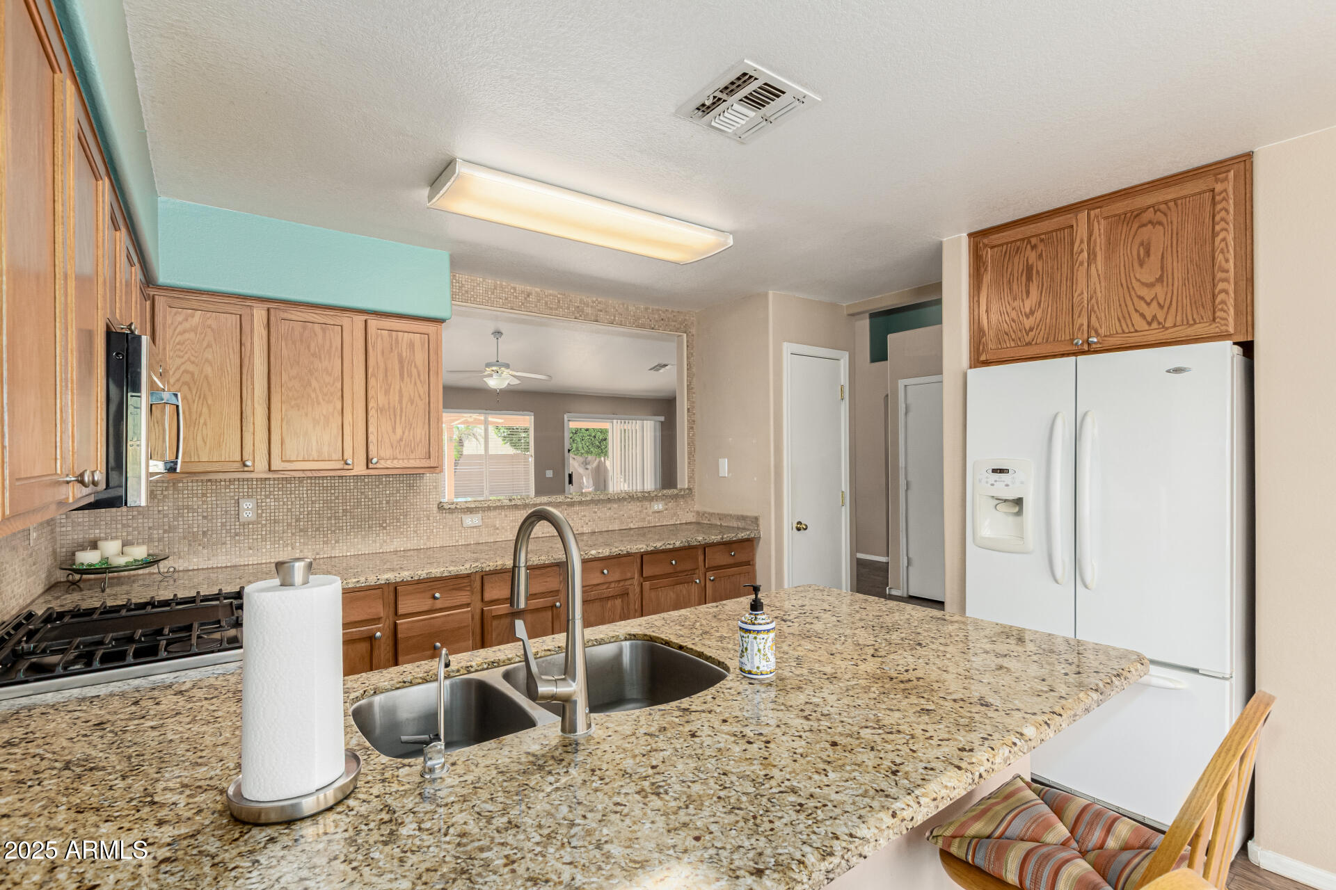 823 West 14th Avenue Apache Junction, AZ 85120 - Photo 14 of 32 a kitchen with stainless steel appliances granite countertop a sink refrigerator and cabinets
