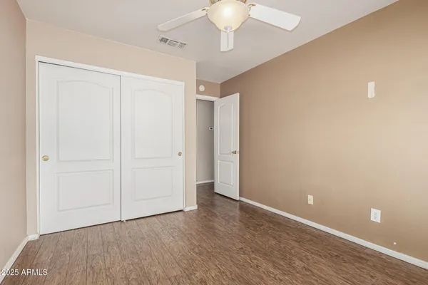 a view of an empty room with a chandelier fan