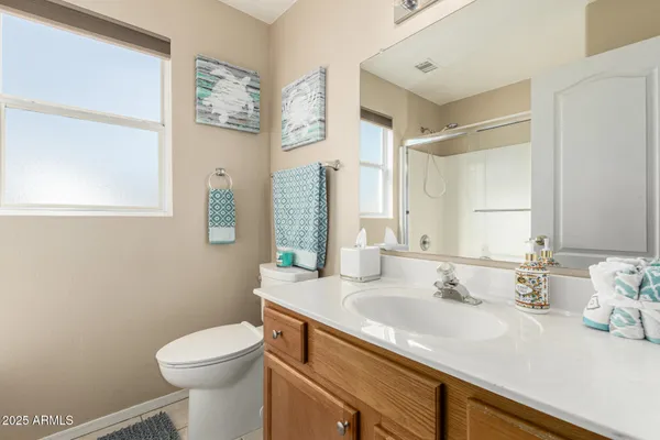 a bathroom with a granite countertop sink mirror and toilet