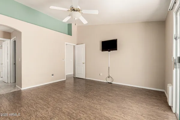 an empty room with closet and a chandelier fan