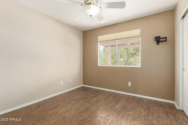 an empty room with a window and a ceiling fan