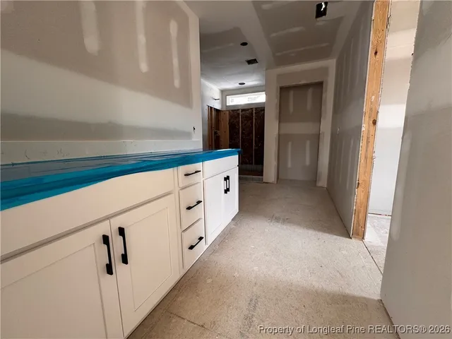a hallway with white cabinets and entryway