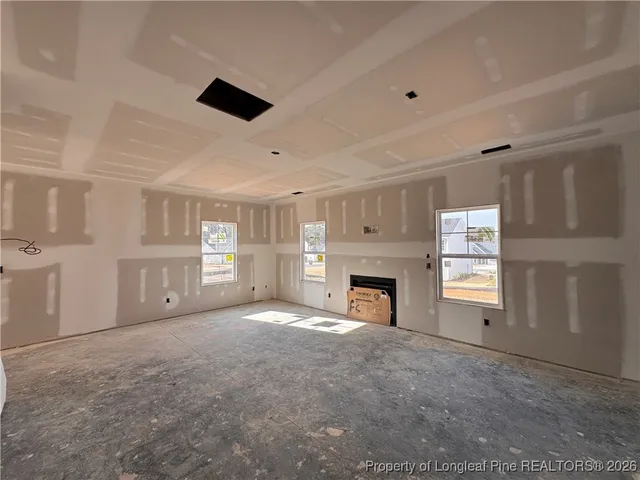 a view of empty room with a fireplace and windows